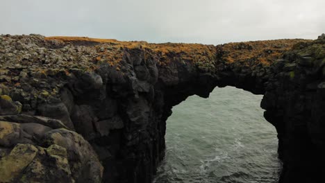 The-beautiful-black-arch-rock-formation-at-diamond-beach-by-the-sea-in-Iceland---wide-shot