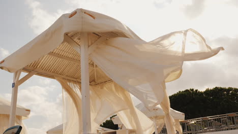 tumbonas de playa con dosel se desarrollan en el viento en el balneario