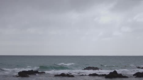 Ocean-waves-on-the-rocks-during-a-cloudy-day