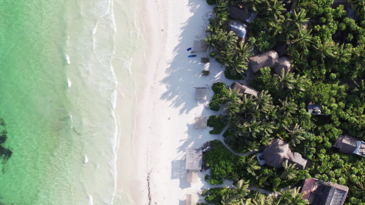 vista aérea de arriba hacia abajo de cabañas y chozas en la hermosa playa de arena blanca en el paraíso tropical en tulum, méxico