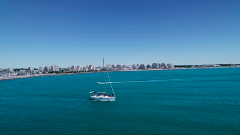 aerial: sail boat motoring out of the bay in the mediterranean sea in montpellier, france