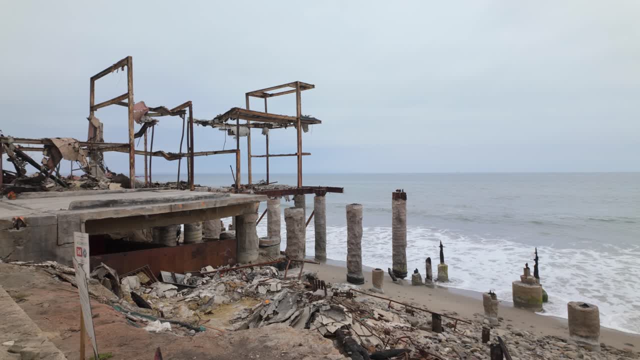 Gimbal wide panning show of a beachfront home that burned in the Palisades Fire in Malibu, California. 4K