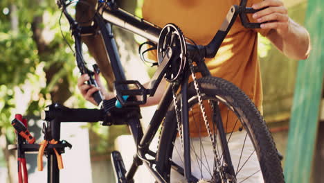 man realigning bicycle pedals in yard