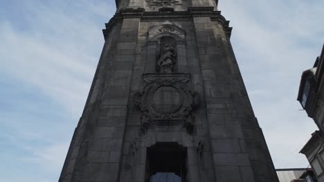 Vista-Inclinada-Hacia-Arriba-De-Una-Torre-De-Iglesia-Cercada-Con-Cirros-Y-Cielo-Azul