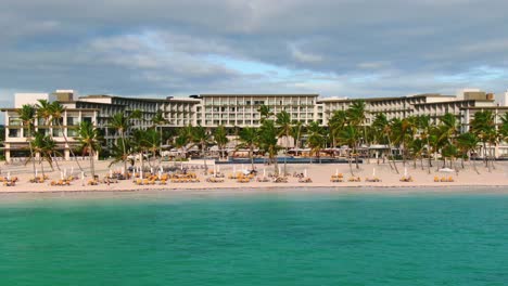 Tropical-seascape,-romantic-beach-with-pristine,-turquoise-sea,-sand-beach-with-palm-trees-and-luxury-vacation-resort-in-Punta-Cana,-Dominican-Republic