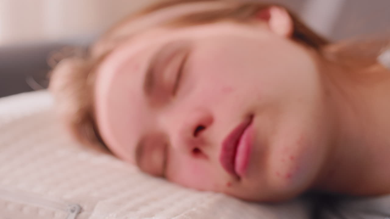 Close up of independent young woman sleeping peacefully on soft pillow with eyes closed, calm face resting in natural daylight, serene and tranquil moment showing relaxation