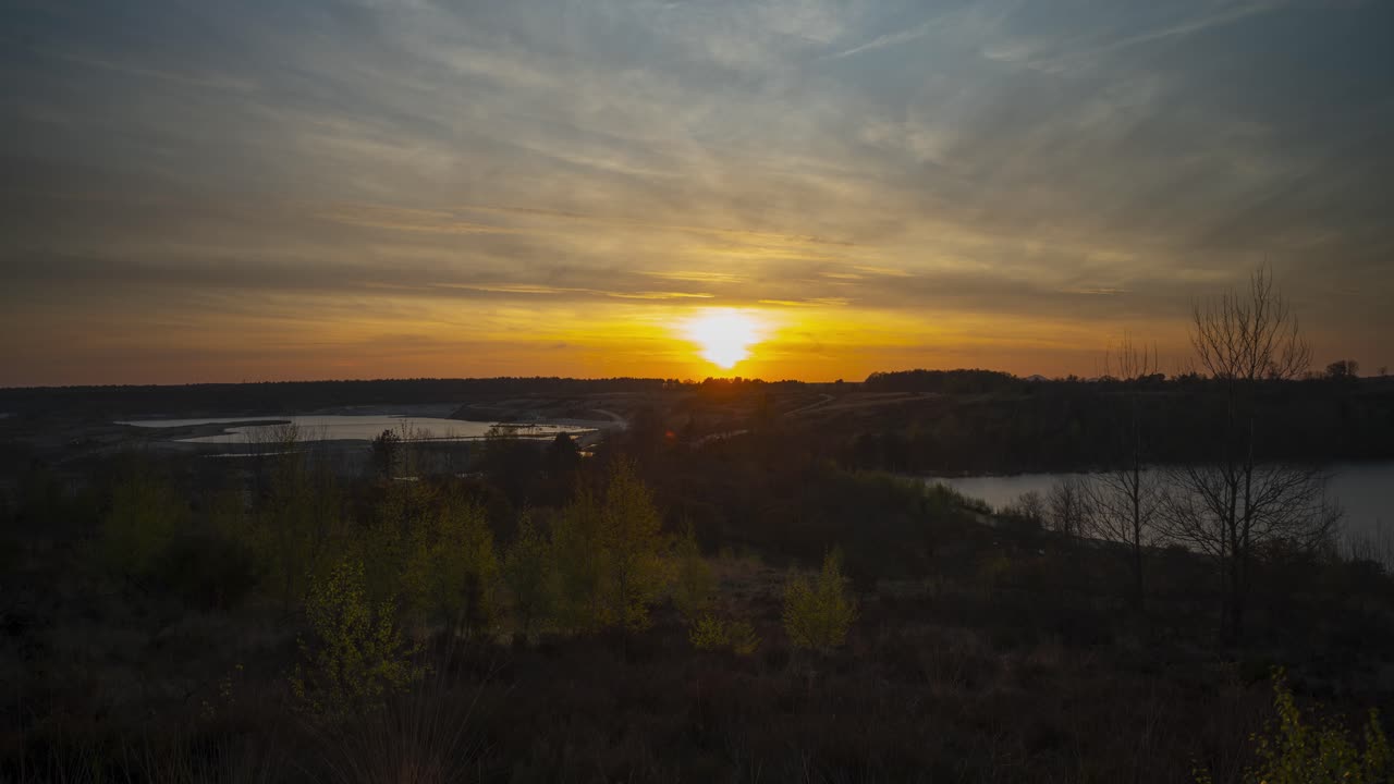puesta de sol brillante detrás de los lagos de la antigua cantera, vista estática de lapso de tiempo