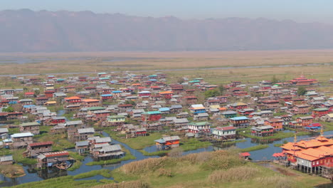 aerial drone panning shot of eain taung gyi stilt house village at inle lake in myanmar