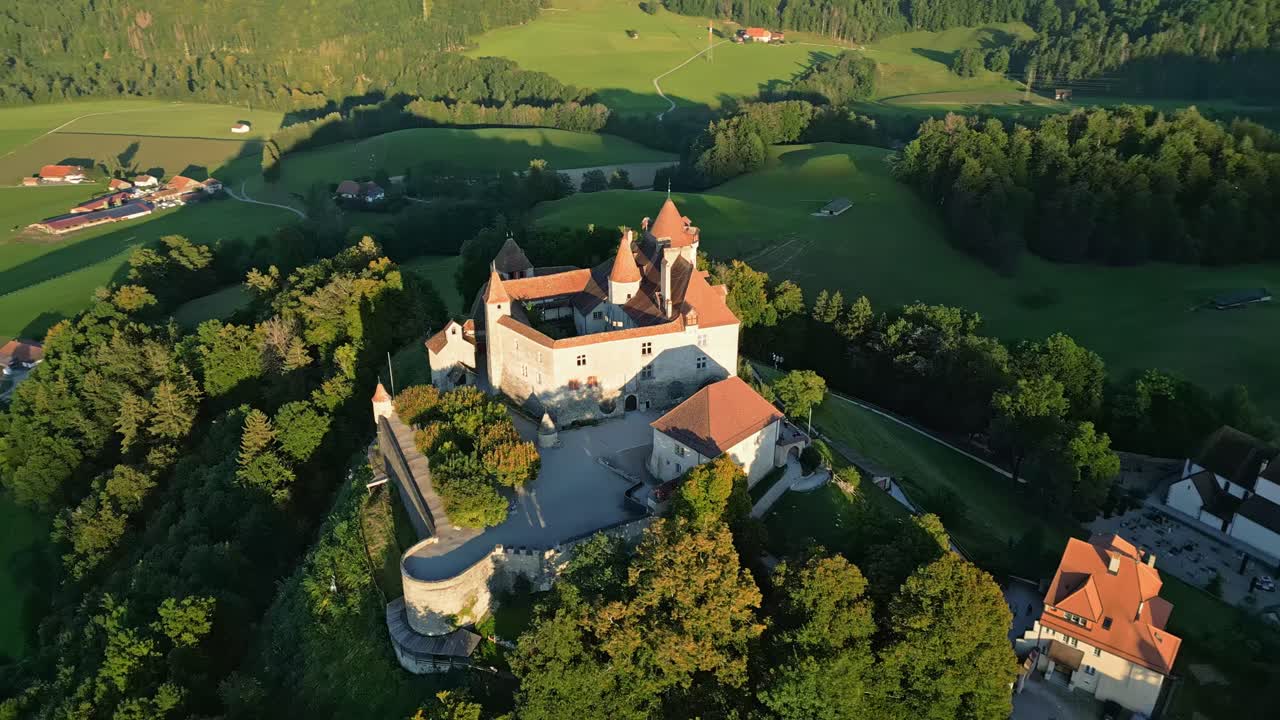 Orbit drone shot at sunset right above Gruyeres Castle in Canton of Fribourg in Switzerland.