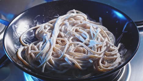 rack focus on a serving of high protein spaghetti with greek yogurt, sprinkled with chopped parsley