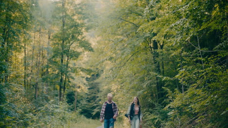 happy friends strolling amidst trees in forest