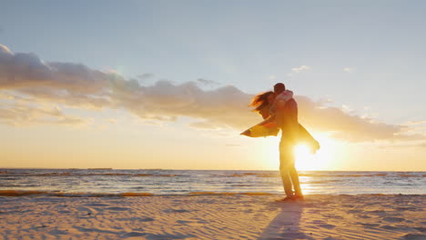 Couple-In-Love-Having-Fun-On-The-Beach-At-Sunset-Berugegu-The-Guy-Turns-Around-Him-His-Girlfriend-Co