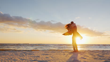pareja enamorada divirtiéndose en la playa al atardecer berugegu el chico gira alrededor de él su novia co