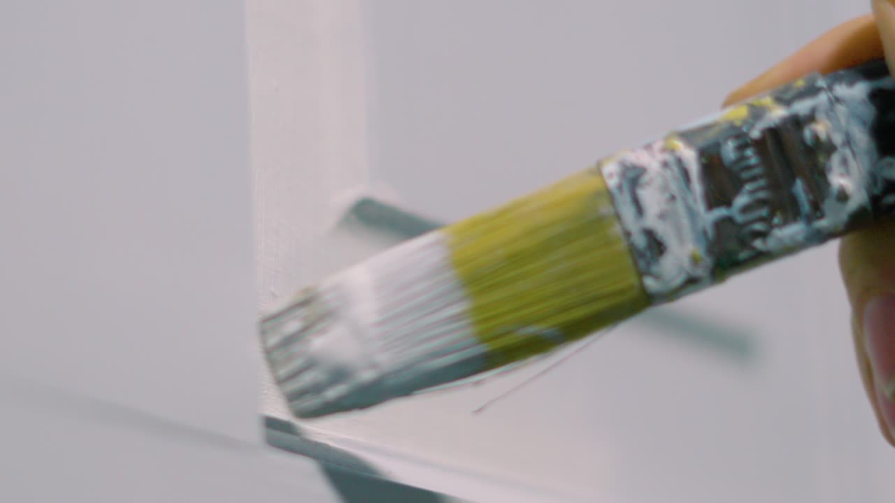Decorator Carefully Applying White Paint Using Small Paintbrush Strokes to Change Color of Door 4K