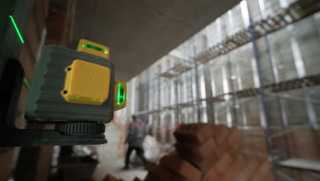 el constructor mide las líneas de reparación utilizando un nivel de láser verde