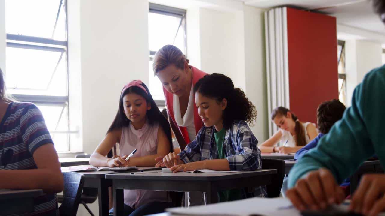 Insegnante che aiuta gli studenti con i compiti in classe