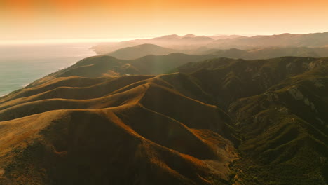 rocky landscape in the rays of setting sun. beautiful mountainous scenery nearby the sea. orange skies at backdrop. top view.