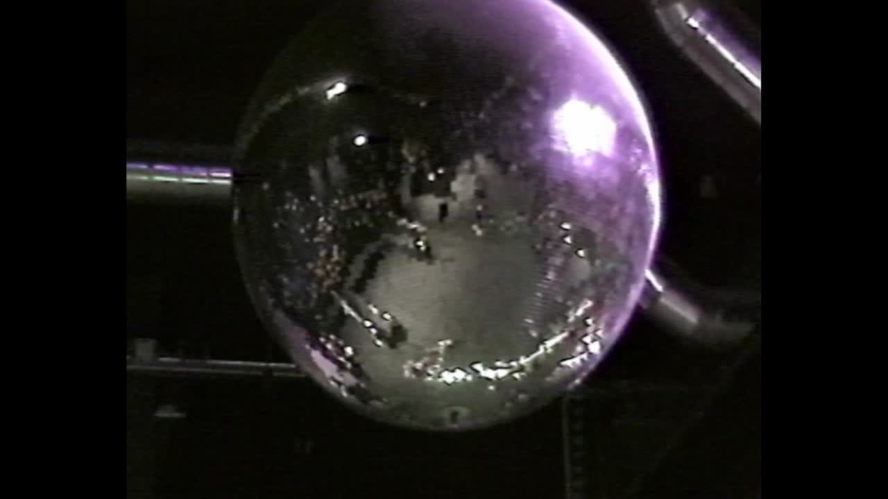 Disco ball above party sign at night