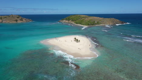 Aerial:-Sandy-Spit---British-Virgin-Islands---Orbiting-shot-revealing-surrounding-area-and-yachts