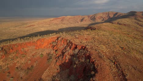 australian desert during sunset time with mountains and clouds at sky in karijini national park