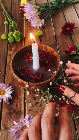 candle and flower arrangement on wooden table