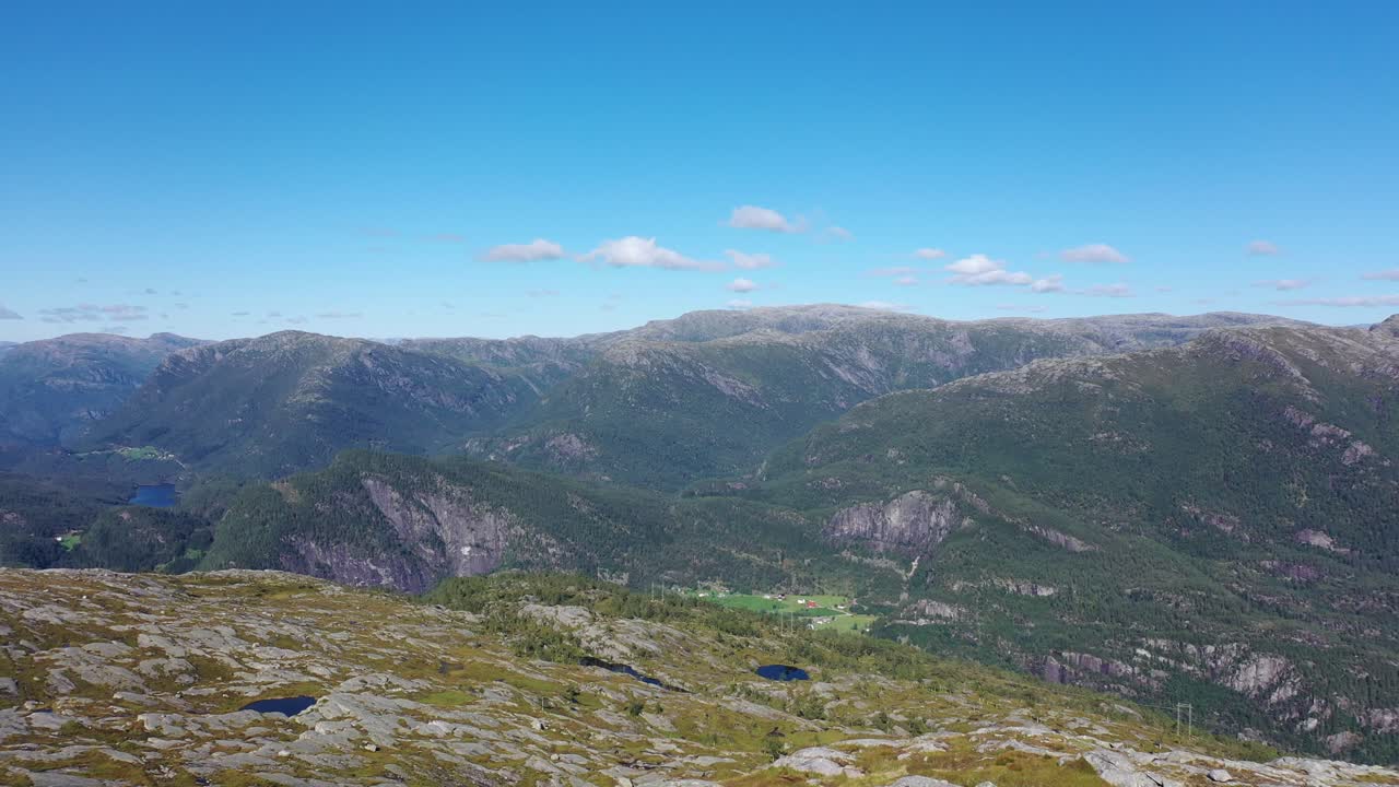 산꼭대기에 있는 남자가 자신의 업적에 도달하고 그의 팔을 공중으로 들어 올려 정상에 도달한 것을 축하합니다 - 공중에 접근하는 남자와 노르웨이 산 풍경을 배경으로 지나가는