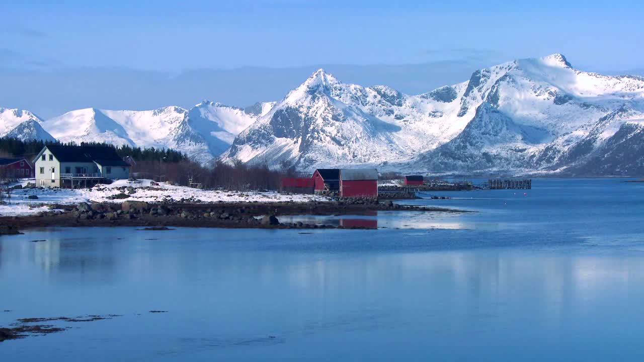 눈 덮힌 봉우리와 호수는 북극 로포텐 섬 노르웨이 1의 외딴 마을을 장식합니다.