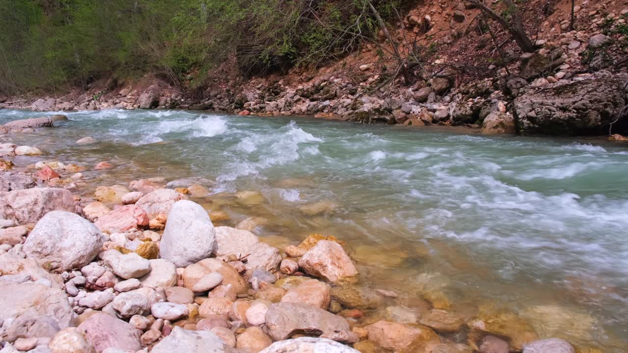 la desembocadura de un río de montaña rocosa fluye. fuerte corriente y agua hirviendo, cascada. el concepto de turismo, senderismo, belleza de la vida silvestre. 4k