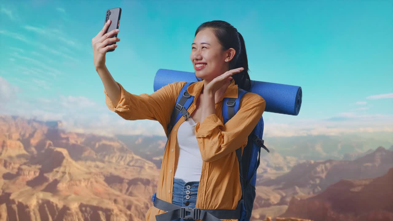 Asian Female Hiker With Mountaineering Backpack While Taking A Selfie While Traveling At The Top Of Mountain