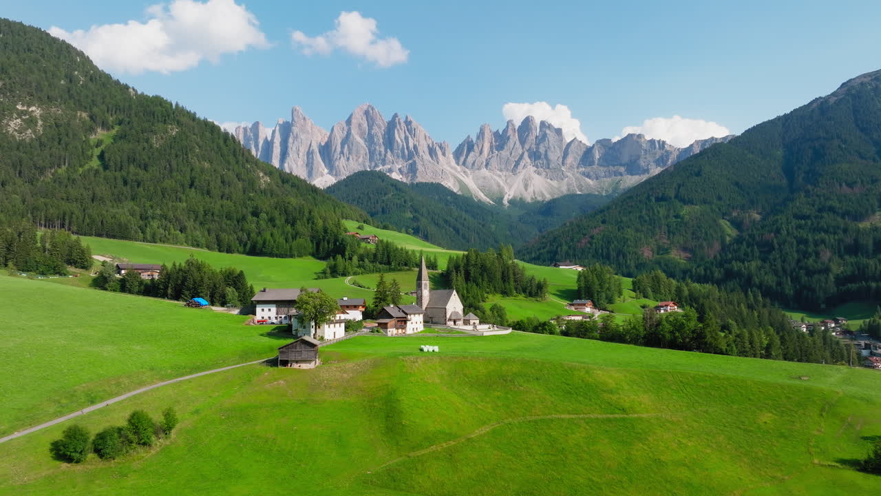 Church of St Magdalena sits beneath the Dolomites in green Val di Funes valley, Italy