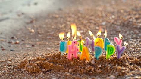 birthday candles burning on a seashore