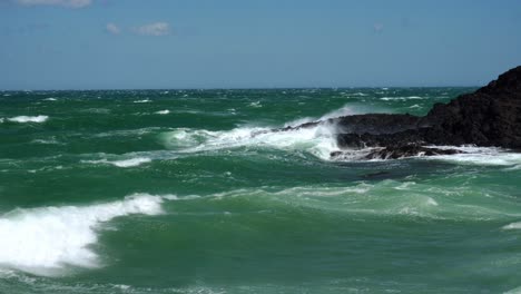 closeup of waves crashing into the coast rocks of collioure in the mediterranean on a summers day with very high gusting winds