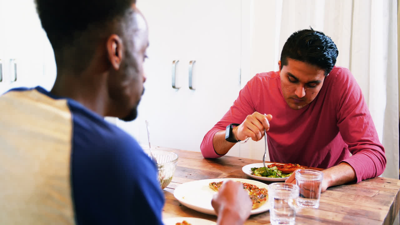 Gay couple interacting with each other while having meal