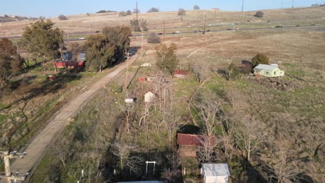 real-time drone footage over clarksville, california, usa showing houses and town buildings moving forwards towards the highway with passing cars and traffic, on a bright sunny day with blue skies