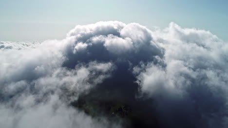 aerial shot of drone passing through dark clouds at daytime