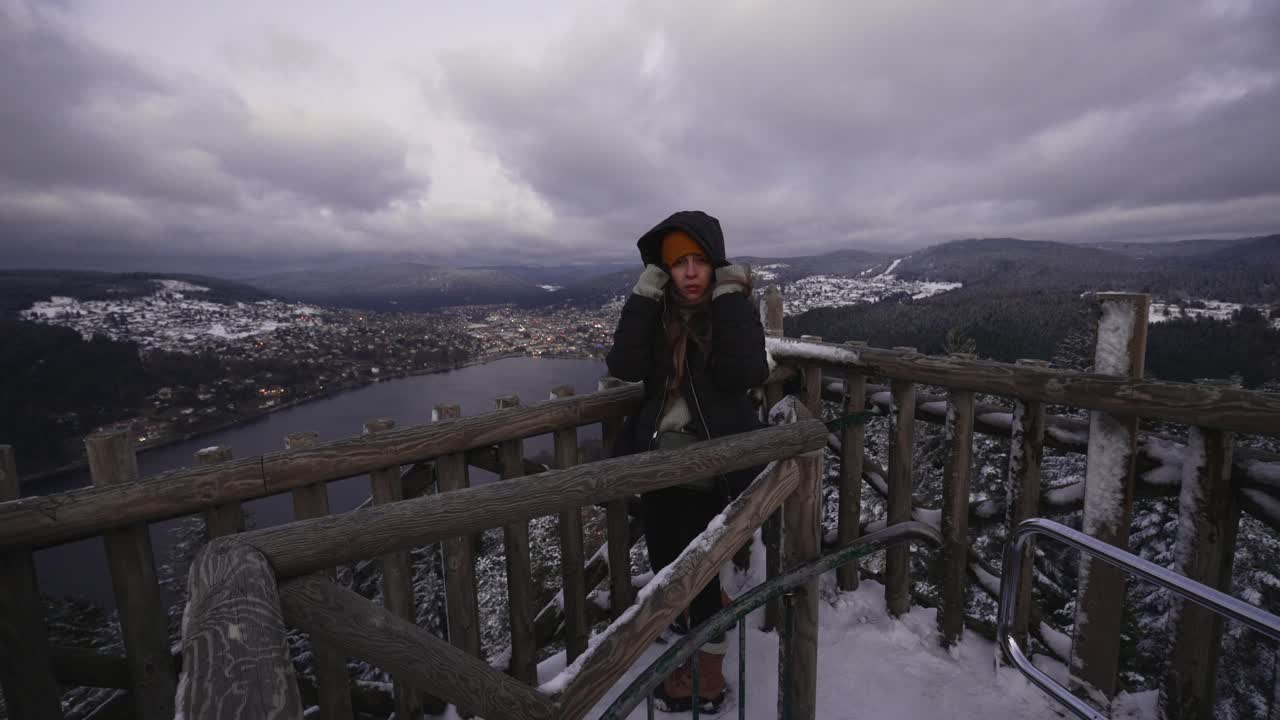joven mirando hacia el lago gerardmer en las montañas vosges en una fría mañana cubierta de nieve