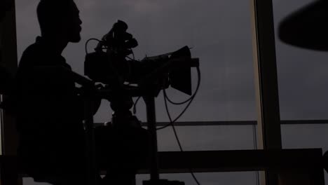 silhouette of a camera crew working together on set before filming