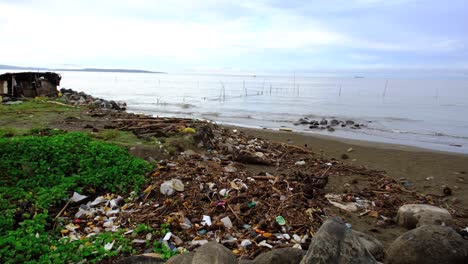 A land full of plastic and other types of materials next to the seaside with new days coming in the background