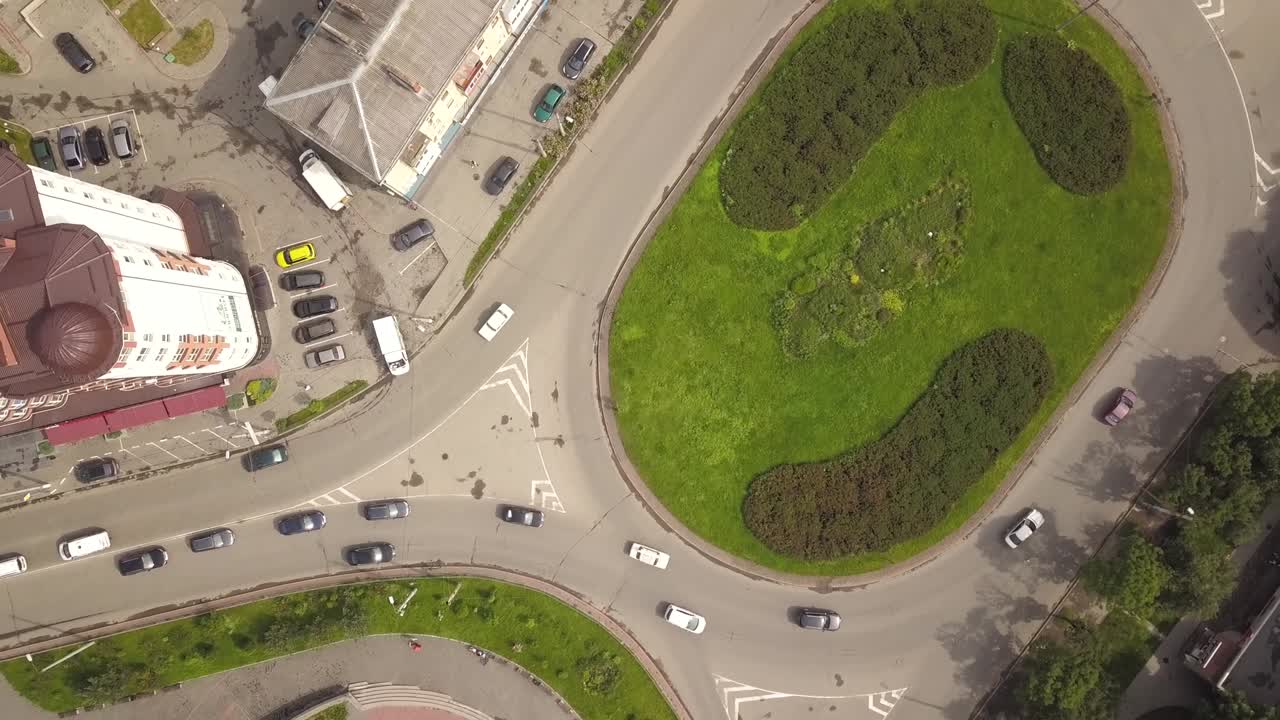 vista aérea de arriba hacia abajo de la intersección de la calle de la rotonda con el tráfico de coches en movimiento.