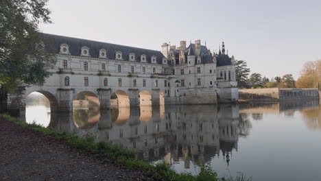 castle of chenonceau reflects in the calm waters of the cher river on a clear day in the loire valley