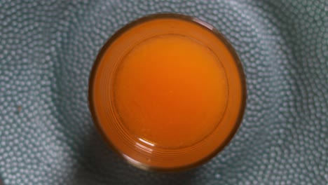 Blick-Aus-Der-Vogelperspektive-Auf-Ein-Orangefarbenes-Gerührtes-Glas-Wasser