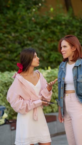 two young women talking outdoors