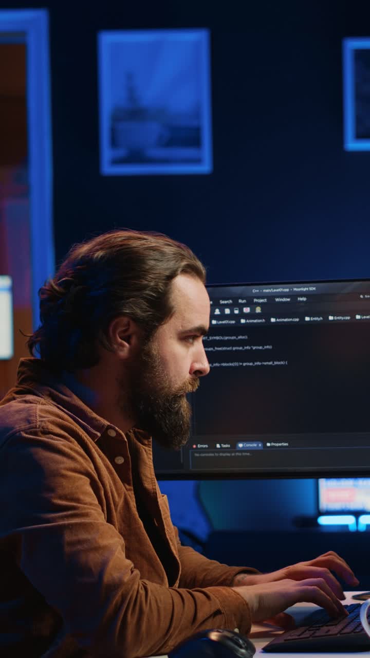 Focused Man Coding on Computer at Night in Dark Office