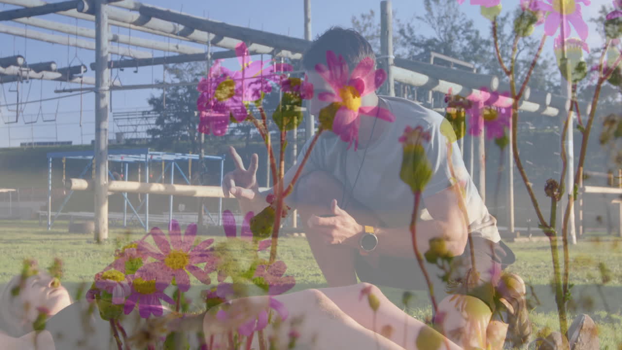 Posing outdoors, man showing peace sign with vibrant pink flower animation