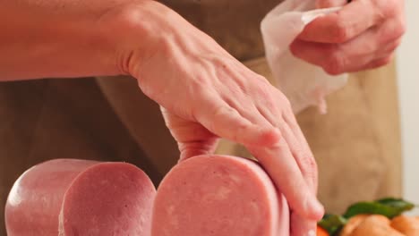 ham italian mordatella, man slices of traditional italian antipasti mortadella sausage on a wooden cutting board, close up macro of chicken or turkey jamon, fat breakfast dish.