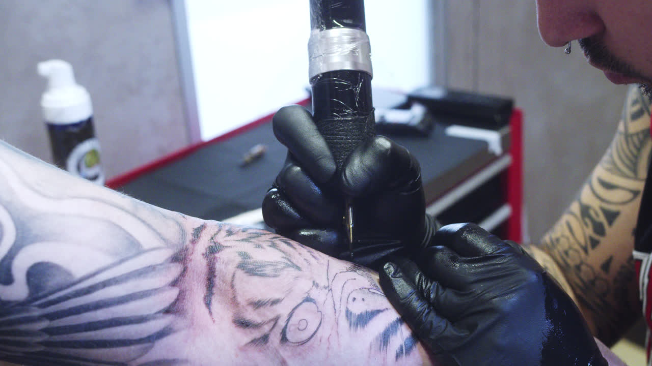 foto lateral de un tatuador profesional en