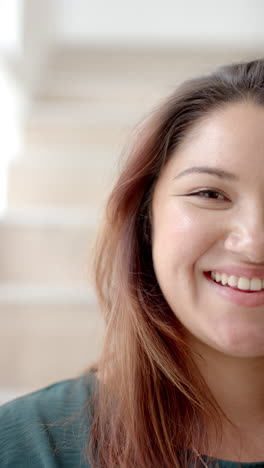 vertical video half portrait of plus size biracial woman smiling at home, slow motion