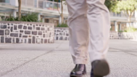 hombre de negocios, piernas y caminando por la ciudad