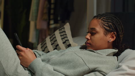 teenage girl using smartphone in bed