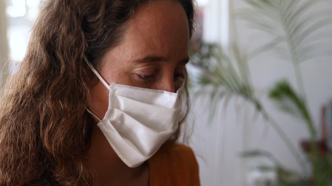 mujer caucásica tomando su temperatura en casa